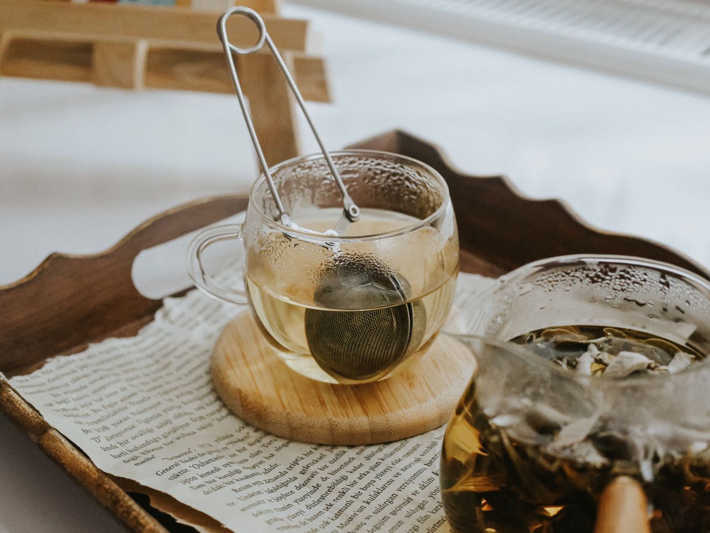 Teeglas mit Sieb auf einem Holztablett