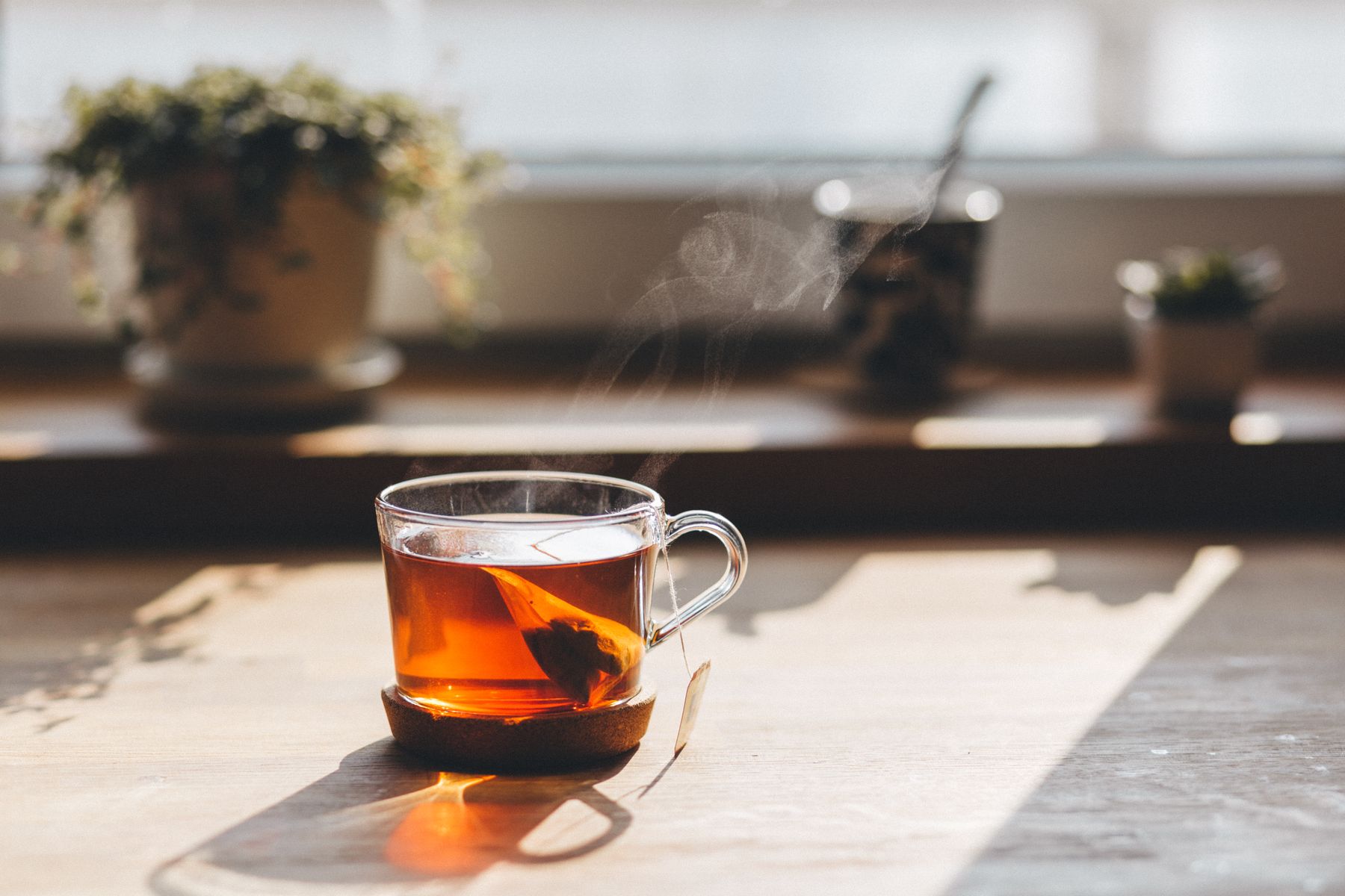 Ein Glas Tee im Morgenlicht auf dem Fensterbrett