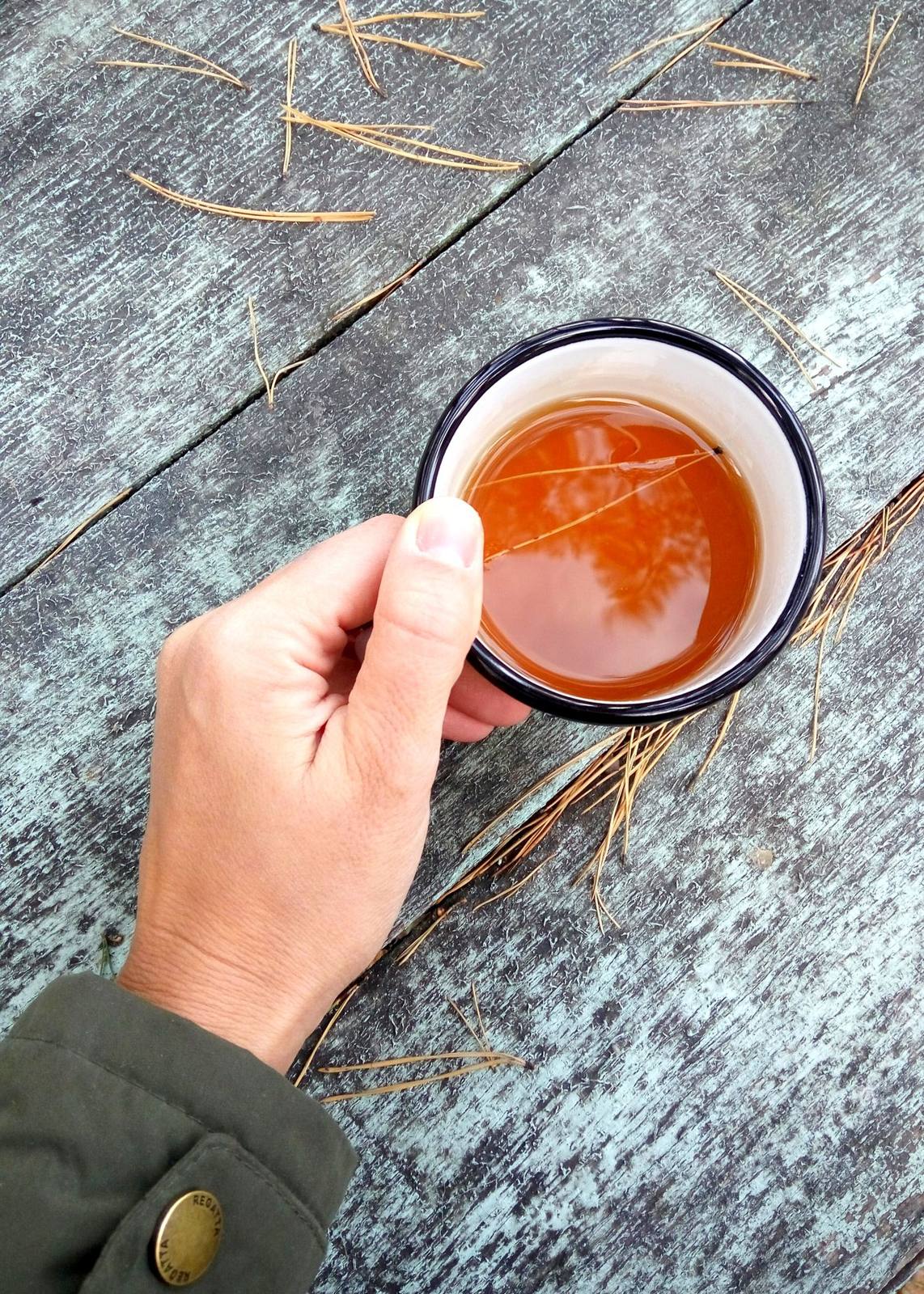 Hand hält eine Tasse Tee