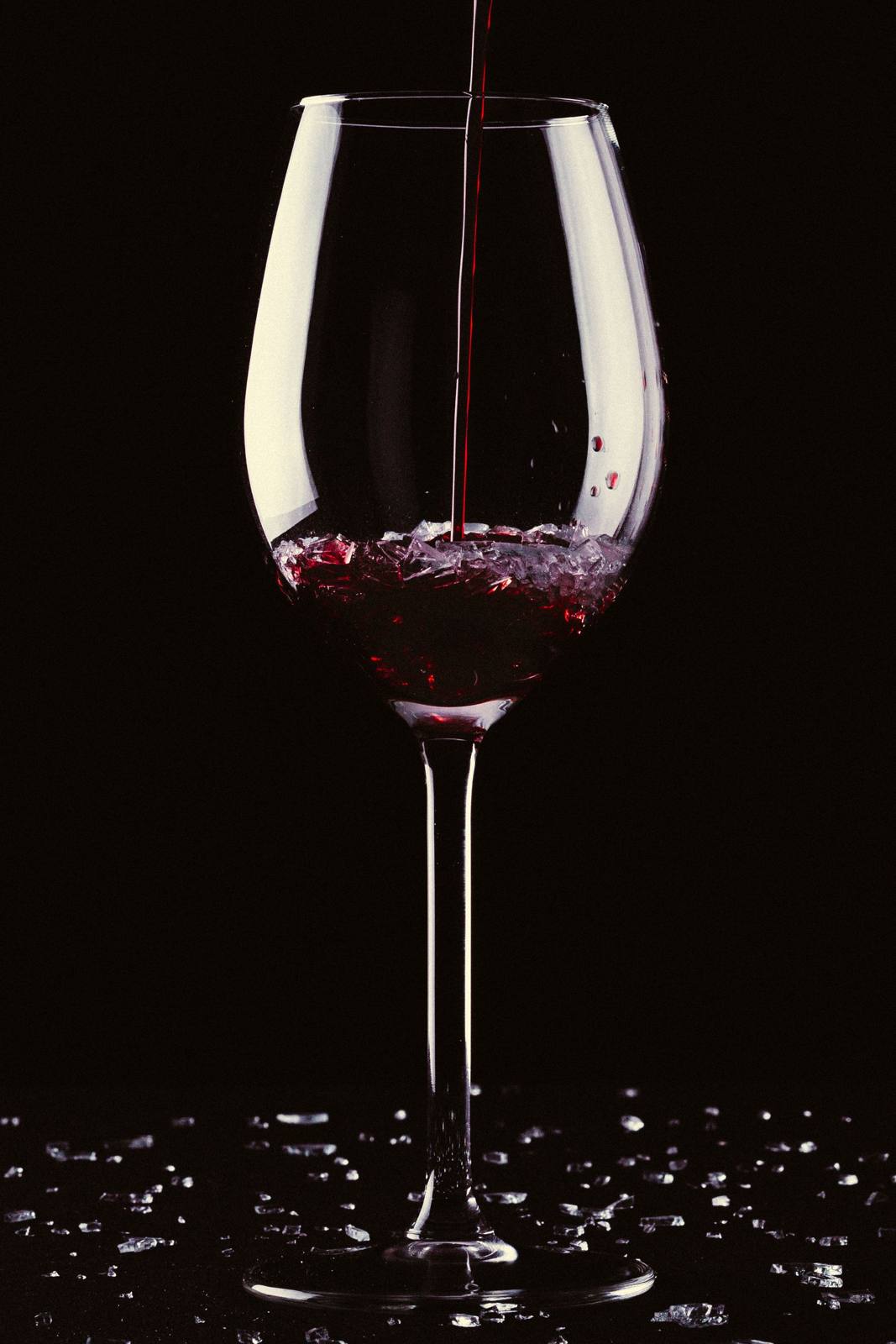 Rotwein wird in ein Glas geschenkt